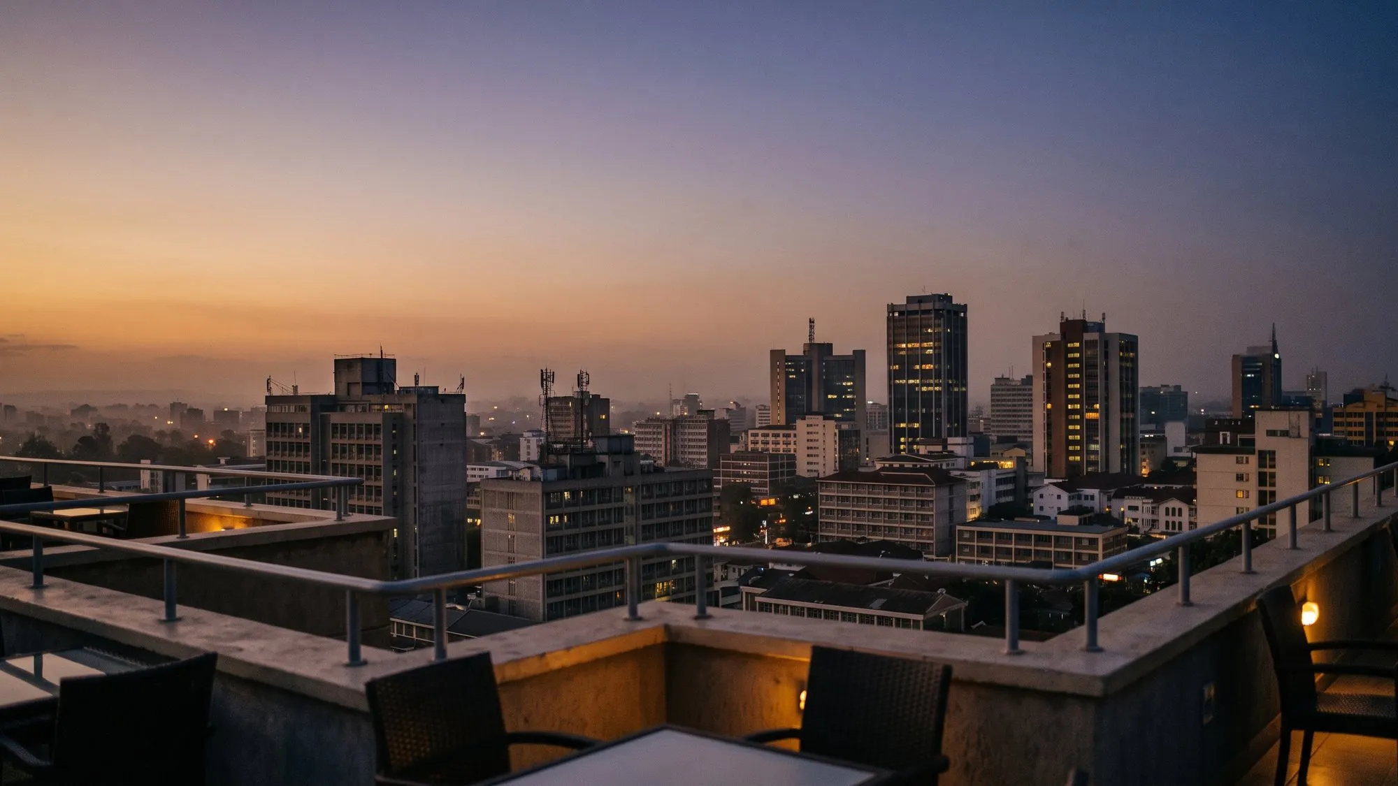 An East African city skyline at dusk, seen from a rooftop